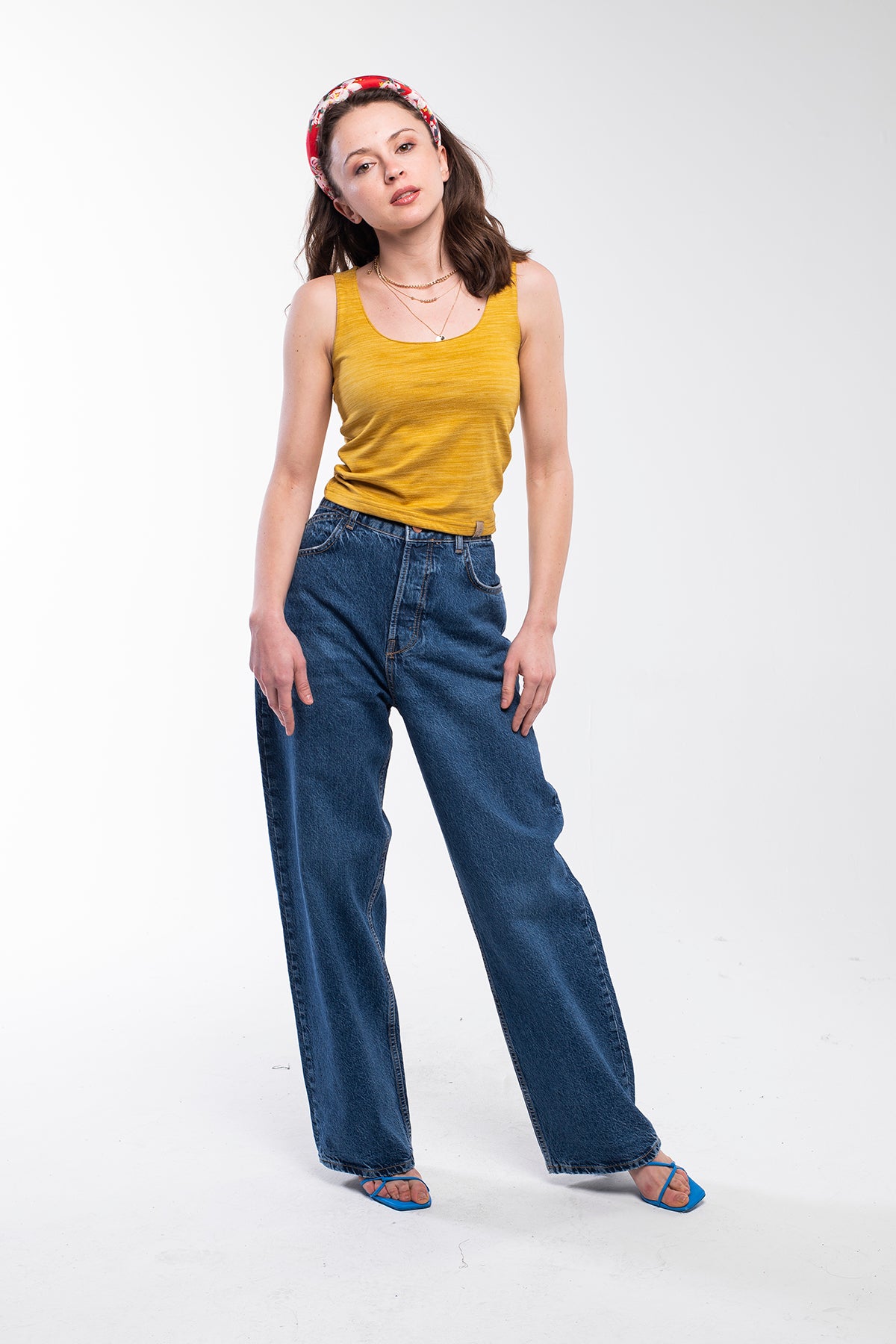 This top features a cropped length and a soft, knitted material in mustard yellow.